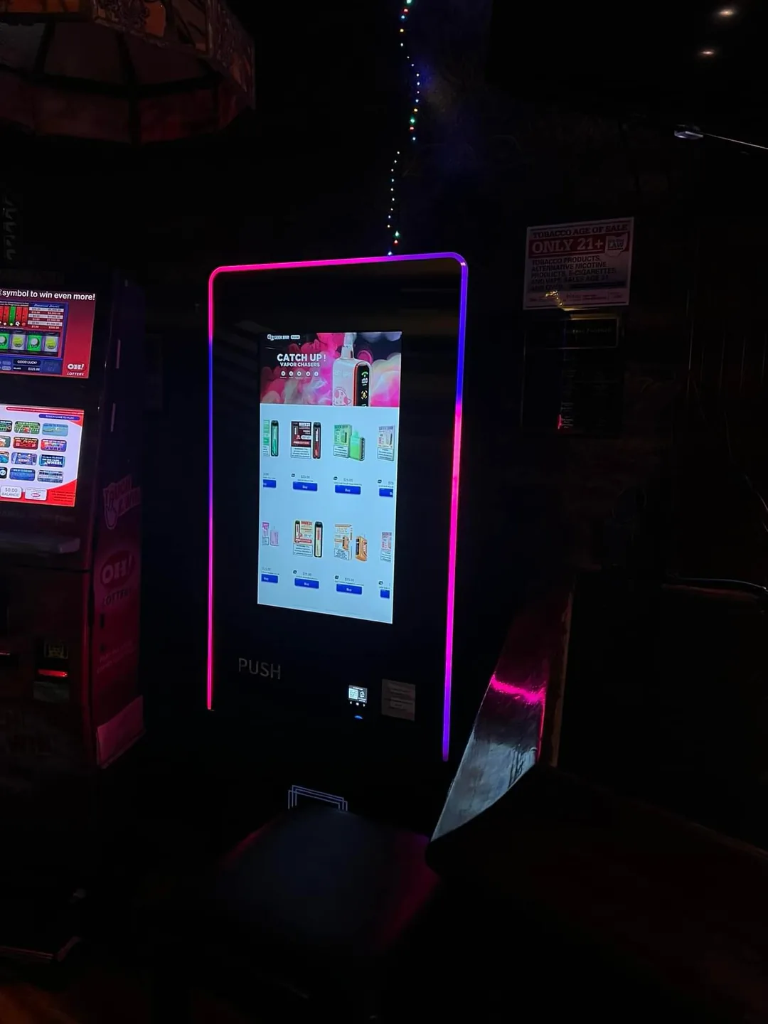 LED-lit touchscreen vape vending machine on a night club floor